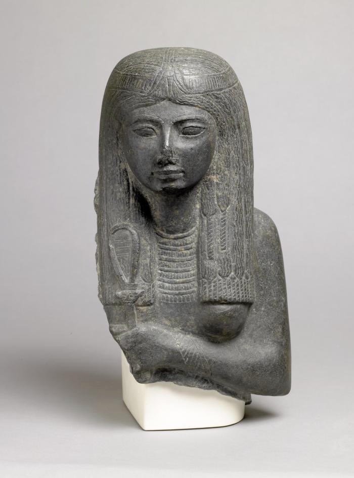 Representación de una mujer sosteniendo un sistro decorado con el rostro de Hathor, c. 1292-1189 a. C., Basalto, Egipto. 1853, 0822.3.© The Trustees of the British Museum (2023)